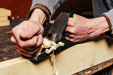 Wall Mural - A carpenter works in a workshop with a saw, planer and various tools