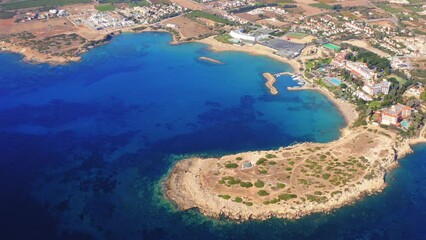 Wall Mural - Aerial view of Cyprus coastal region with deep blue sea and rugged coastline with bay, hotel and beaches under bright sunlight