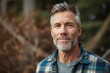 Rustic studio portrait of a middle-aged man in a flannel shirt, embodying a rugged, outdoorsy lifestyle, against a natural, woodsy background