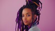 A young African American woman with lilac dreadlocks on a light lilac background.