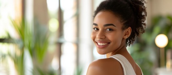 Wall Mural - Happy African American woman at home applying nourishing cream or lotion to her shoulder, with copy space.