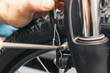 closeup hand of bicycle mechanic adjusting brake