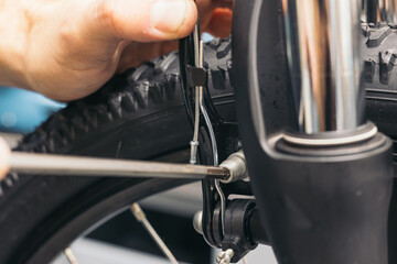 Wall Mural - closeup hand of bicycle mechanic adjusting brake