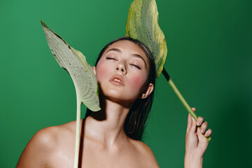 Poster - An Alluring Portrait of a Young, Attractive Female in Green Fashion, Radiating Beauty and Elegance against a Bright Studio Background