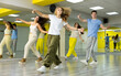 © JackF - Group of young confident teenagers in casual clothes dancing together during exercise in class