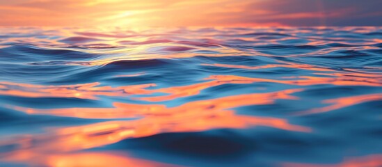 Poster - The water reflects orange and blue skies during sunrise.