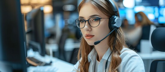 Canvas Print - Female helpline worker in call center office, using computer, is attractive.