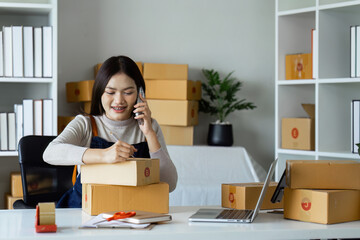 Young business woman entrepreneur online shipment business is preparing packages to send to customer. e-commerce concept