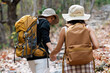© itchaznong - Happy LGBT Lesbian couple Travelers Hiking with Backpacks in forest Trail. LGBT Lesbian Couple Hikers with backpacks walks in mountains in vacation