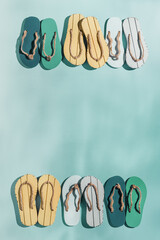 Wall Mural - Summer flip flops flat lay, beach footwear vivid colored, top view still life with woman slide sandals, shoes on turquoise background, summer beach holiday concept, underwater sunlight