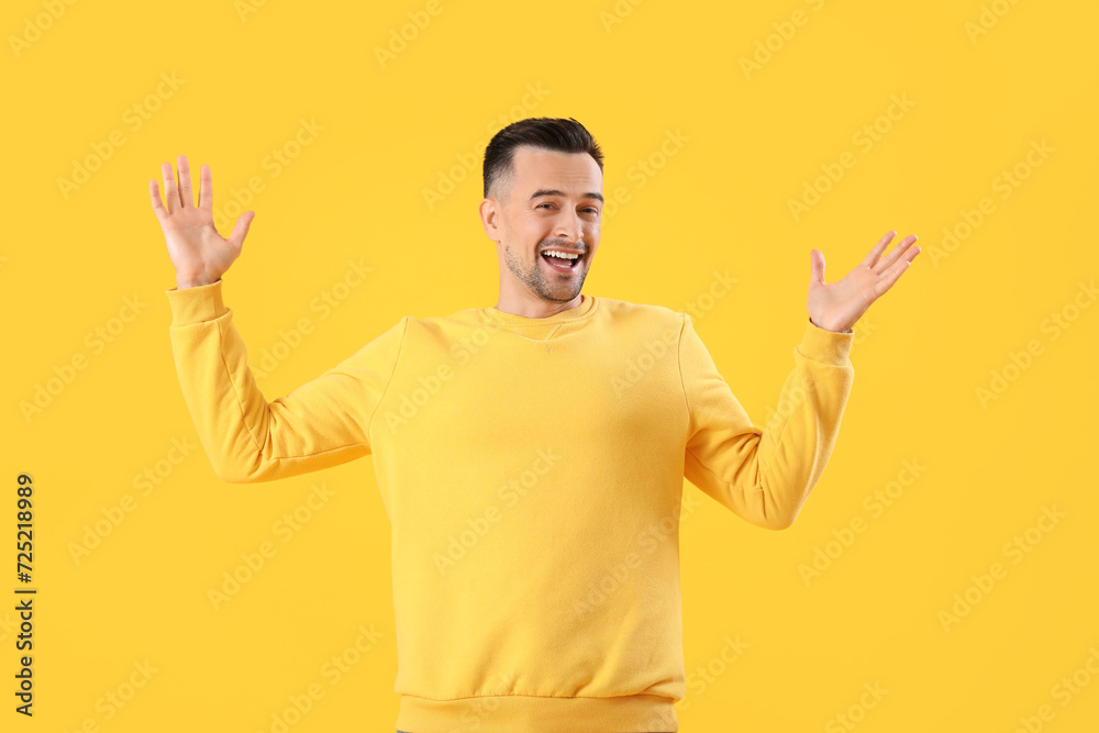 Happy young man on yellow background