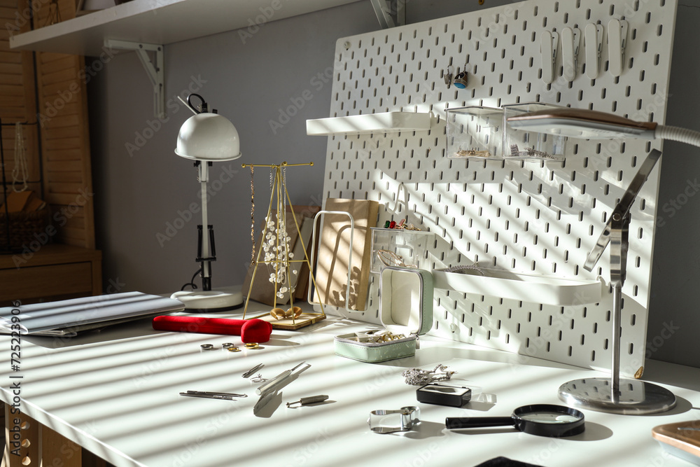 Stylish accessories with tools on table of jeweler in workshop