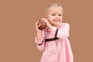 Wall Mural - Happy little girl with chocolate egg on brown background. Easter celebration