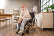 Young redhead woman in wheelchair at home