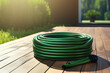 Garden hose with on a wooden deck in the garden.