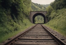 Rusty Train Tracks Lead Into A Dark Tunnel In A Desaturated Landscape