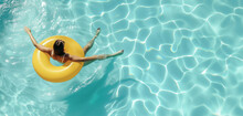 An Overhead Shot Of A Woman Relaxing On A Bright Yellow Float In The Tranquil Blue Waters Of A Pool