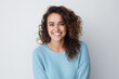 © Postproduction - Joyful woman with curly hair wearing light blue sweater. Positive emotions and confidence.
