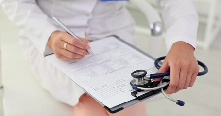 Wall Mural - Hands of a doctor filling out written medical documents in clinic