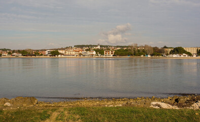 Wall Mural - The coast of the Kasteja Forest Park - Park Suma Kasteja - in Medulin, Istria, Croatia. Medulin town is in the background. December