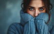 © VISIONARTIST - Woman in blue turtleneck knitted sweater looking at camera while covering sad face. Feelings of depression, sadness, loneliness, social phobia. Winter cold. Blue Monday.