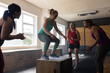 © Wavebreak Media - Diverse females cheering woman jumping on wooden plyo box in health club, copy space