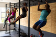 © Wavebreak Media - Multiracial females practicing chin-ups on gymnastic bars in health club