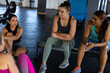 © Wavebreak Media - High angle view of multiracial female friends talking while sitting in health club after workout
