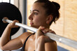 © Wavebreak Media - Closeup of dedicated caucasian young woman lifting barbell confidently in health club
