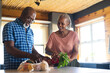 © Wavebreak Media - Happy senior african american couple unpacking groceries in kitchen