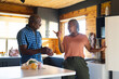 © Wavebreak Media - Happy senior african american couple unpacking groceries in kitchen