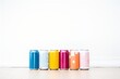 unlabeled cans with various colors on white table