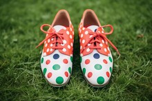 Closeup Of Oversized Polka Dot Clown Shoes On Green Grass