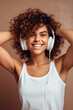 © Synthetica - Portrait of a smiling young woman listening to music with headphones .