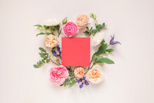 Overhead View Of Roses, Chrysanthemums And Alstroemeria Flowers Arranged Around A Blank Pink Card