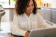 © opolja - Smiling young black woman freelancer working from home, using laptop, copy space. Relaxed african american lady enjoying her weekend, surfing on internet on laptop