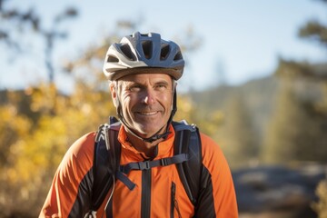 Wall Mural - Portrait of senior man with bicycle helmet in the mountains. Sport and active life concept.