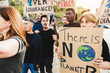 © DisobeyArt - Multigenerational people protest against climate change - Crowd doing demonstration for stopping pollution - Green and environment concept - Focus on right banner