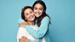 © Art AI Gallery - Happy mother and daughter hugging and looking at camera isolated on blue background
