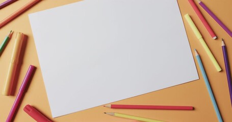 Canvas Print - Overhead view of blank sheet of paper with school stationery on beige background, in slow motion