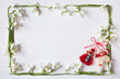 White wooden background with spring flowers snowdrops in the form of a frame and red and white martenitsa for the holiday of March 1