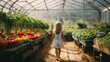 © anandart - girl walking backwards in the greenhouse with planted vegetables, vegetables in a garden without agrochemicals. Sustainable living and circular economy concept, space for text