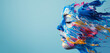 face made from colorful paint splatters, poured dripping down isolated on plain blue background with copy space