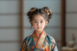 little asian girl in traditional japanese kimono looking at camera