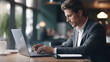 © redflower - A businessman working on a laptop computer in a modern office