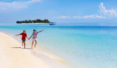 Wall Mural - Kids play on tropical beach. Sand and water toy.