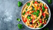 Vista superior de un plato de ensalada de pasta con tomate, lechuga, albahaca como ejemplo de comida sana
