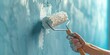 A person using a paint roller to paint a wall. This image can be used for home improvement or renovation projects