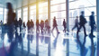 © Fareedoh - Blurred motion of business people walking briskly in a modern corporate office lobby with cityscape background.