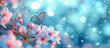Butterfly on cherry blossoms with bokeh lights on a blue background. Springtime nature and wildlife concept. Design for greeting card, invitation, banner, poster. Macro shot with copy space.